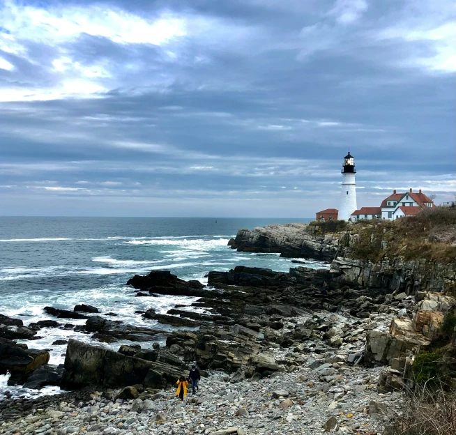 the two people are walking up to the lighthouse