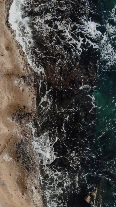 a boat traveling through the water next to rocky shore