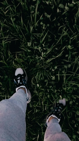 a persons feet that are standing in the grass