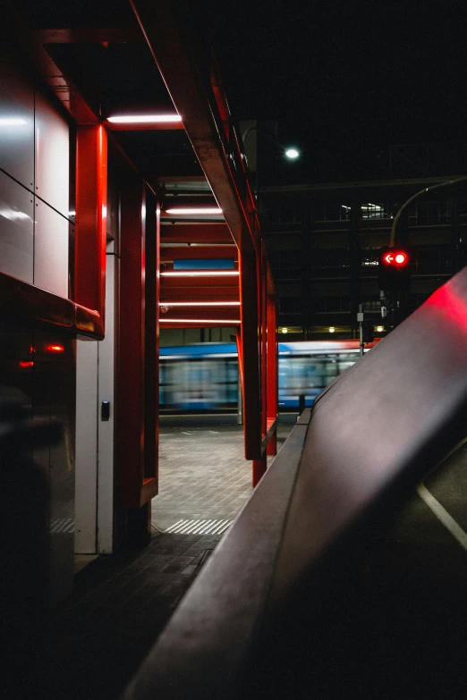 an empty walkway that has red light on the ceiling