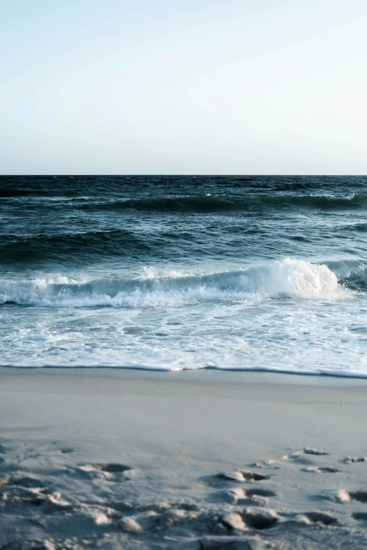 a person standing on the beach next to a body of water