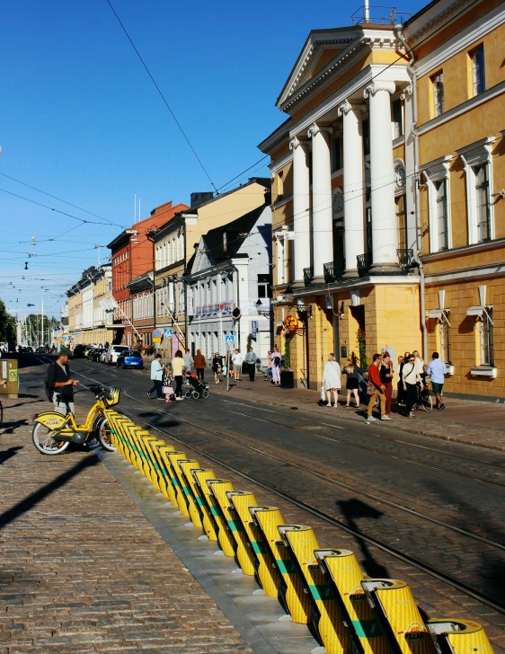 a narrow street with people walking, and some buildings