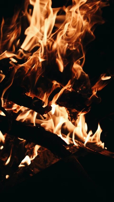 a fire pit with bright red flames and wood sticks