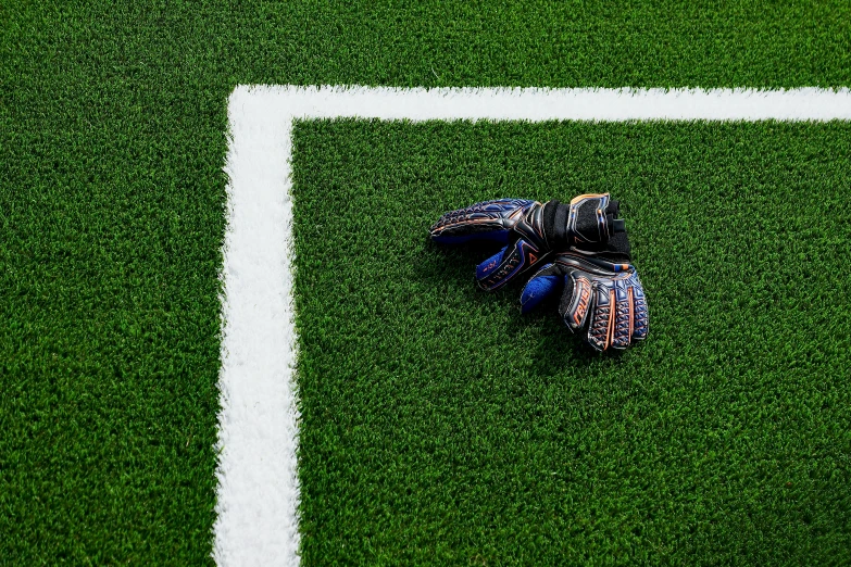 a glove is laying on the grass near a soccer ball