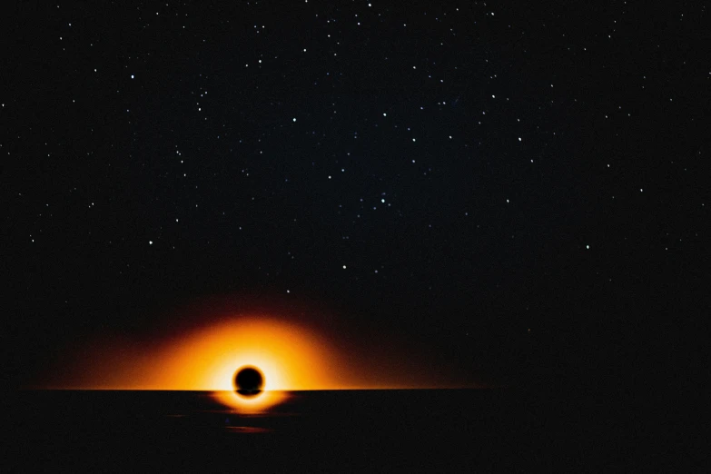 a person silhouette against an orange glow in the night sky