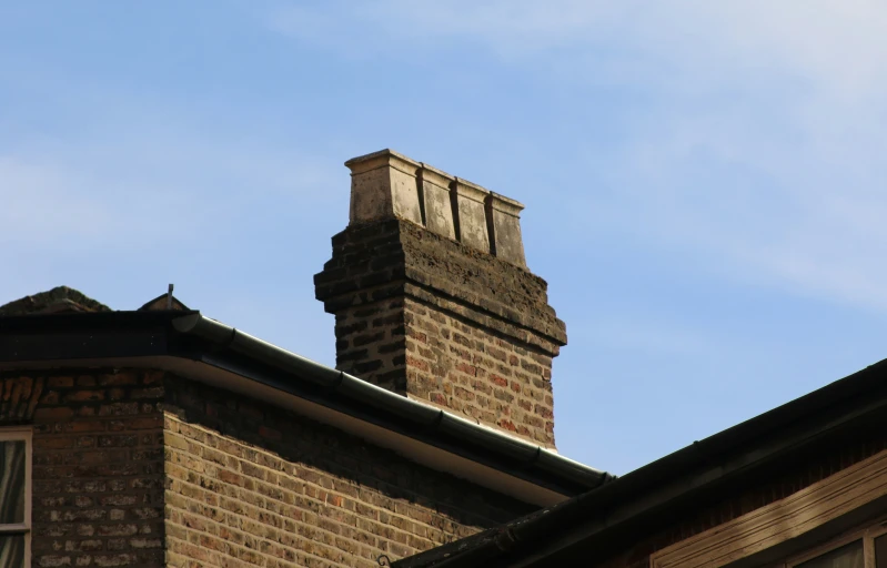 a brick chimney sits on the roof of a house