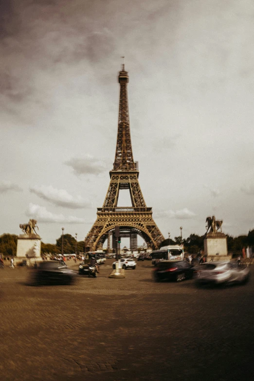 the eiffel tower is pictured from the ground in front of the cars