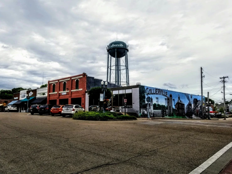 a street with lots of cars and a water tower in the background