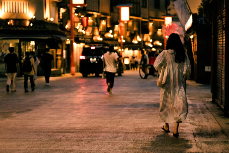 the woman is walking down the street holding an umbrella