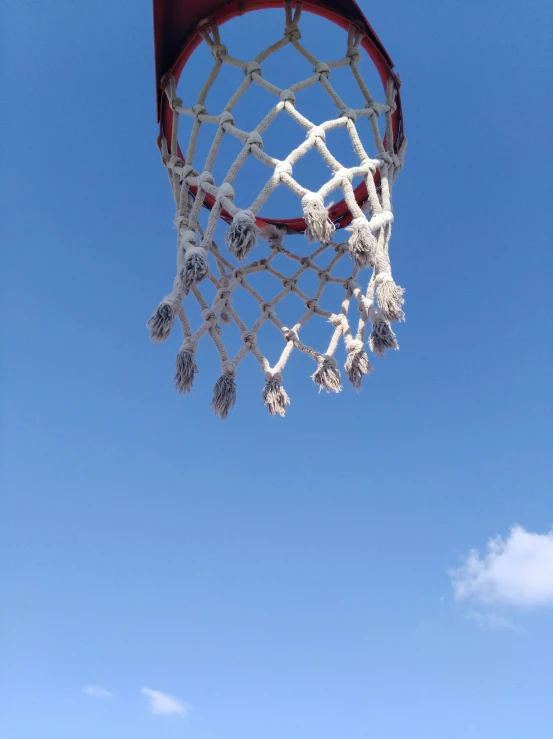 a close up of a basketball net and the sky