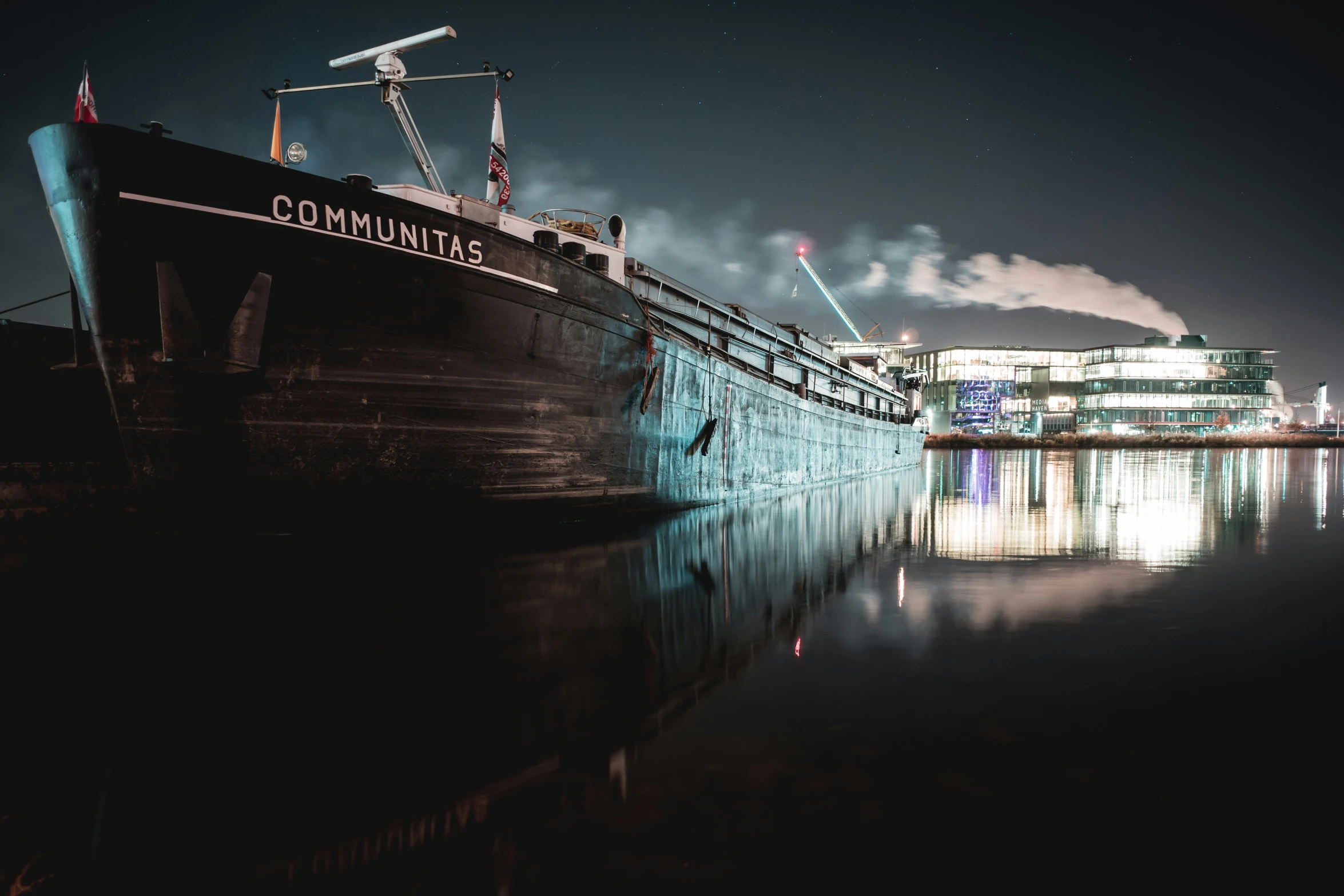 a large boat docked in a harbor at night