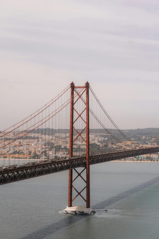 a view of a large bridge with a boat on the water