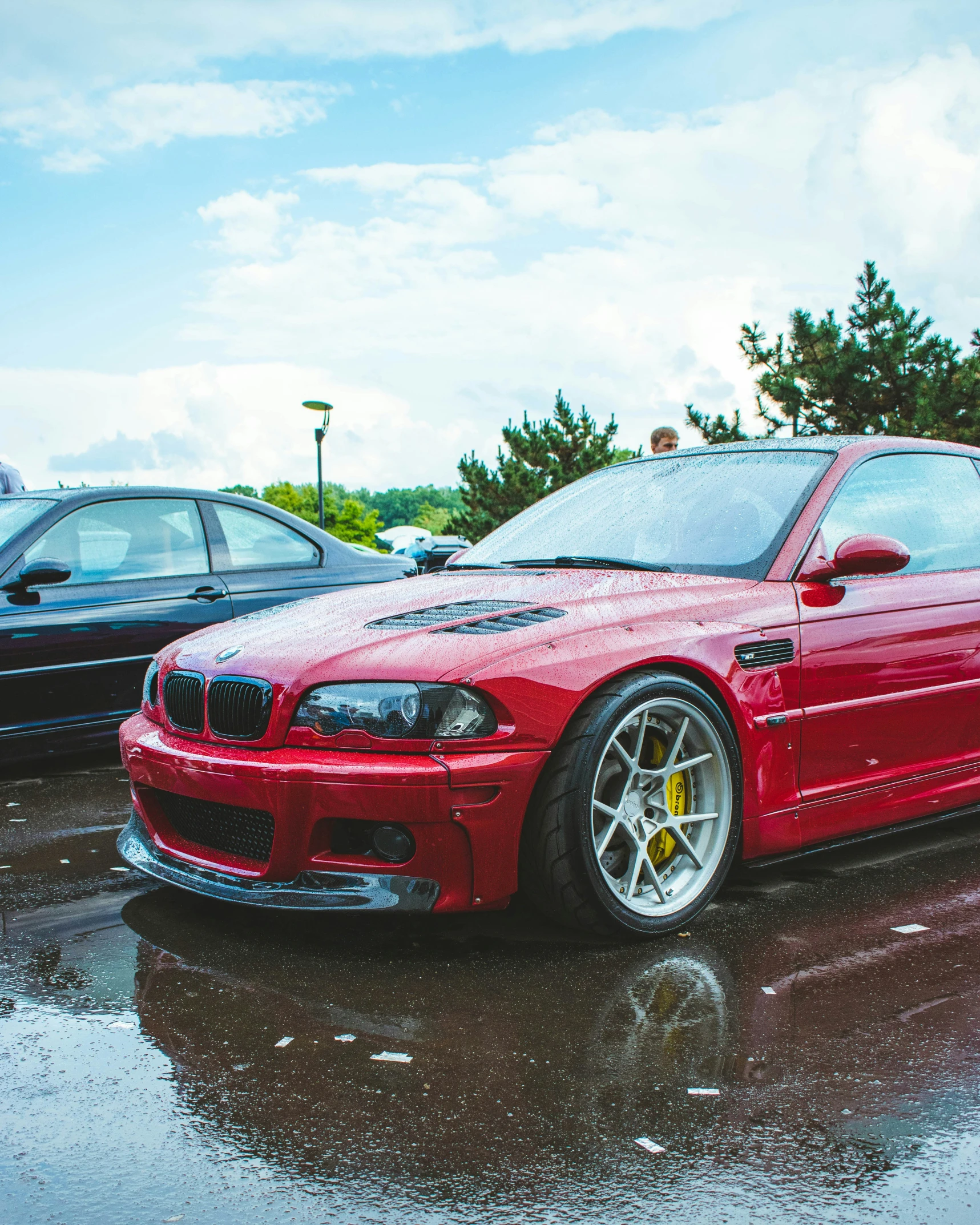 a red sports car sits on the wet pavement