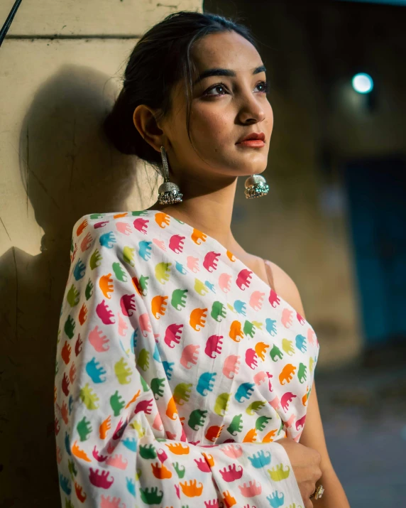 a woman wearing a colorful robe with earrings and pearls