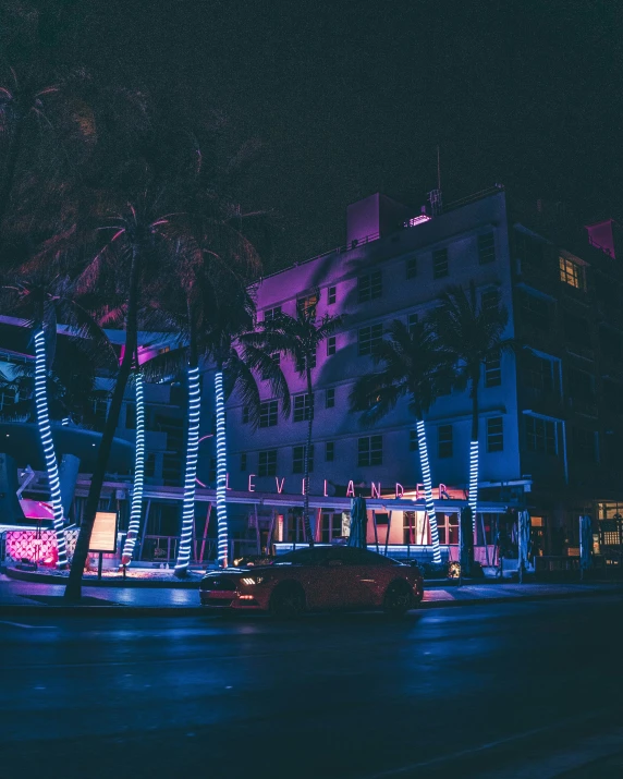 brightly lit building stands near a road at night