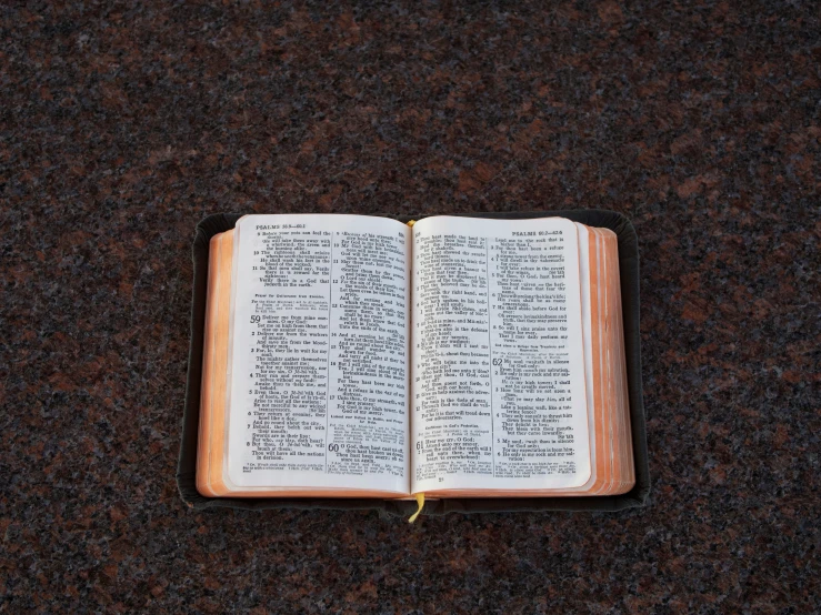 an open bible is sitting on a black carpet