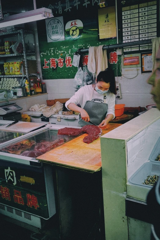 two people preparing food in front of a shop