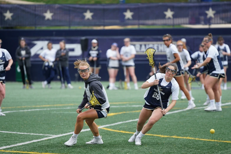 the women are competing at a lacrosse game