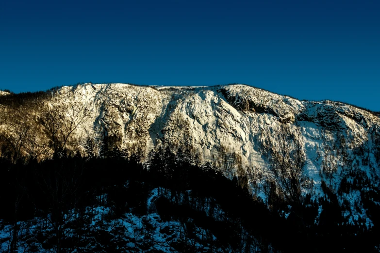 a snowy mountain covered in snow under a clear sky