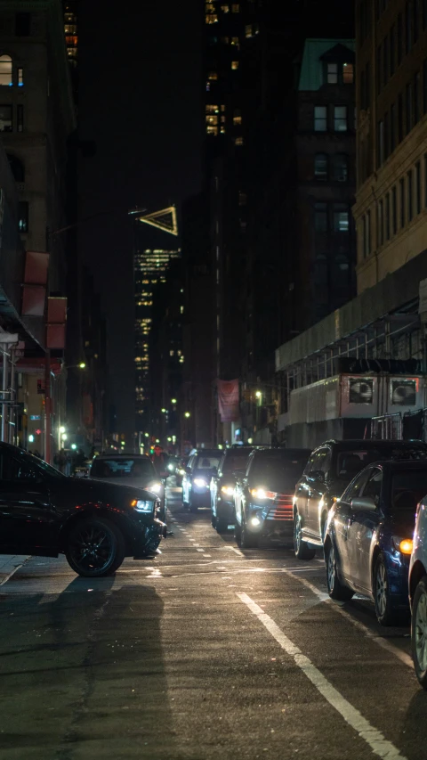 the busy city street is lined with cars at night