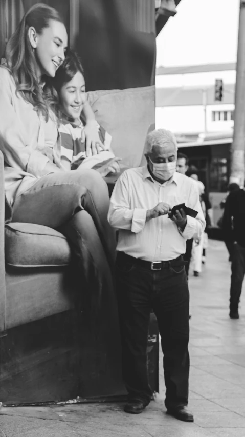 a woman with a phone standing next to a man holding an object