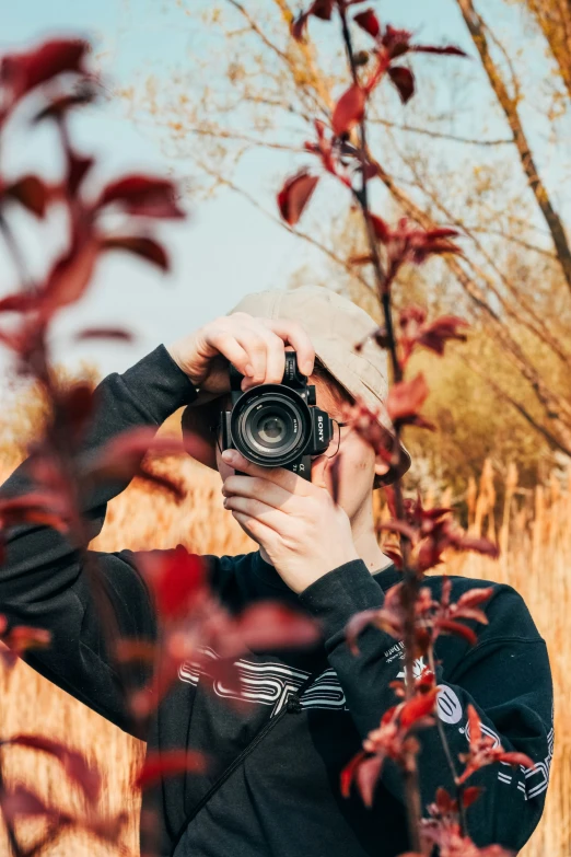 a man standing in front of a tree with a camera