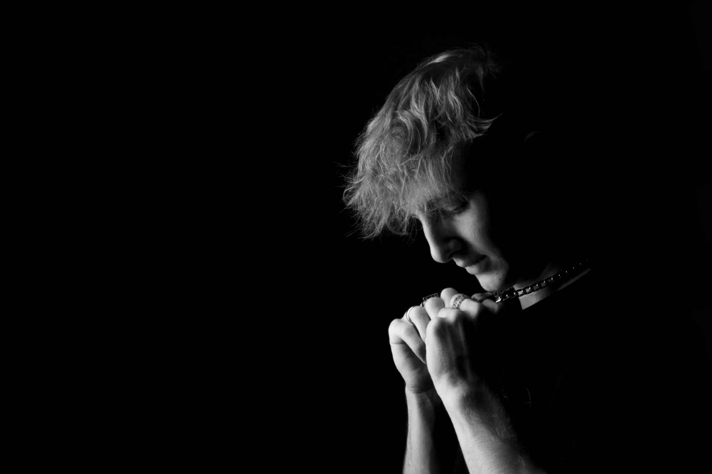 a black and white image of a woman with her hands folded over her face