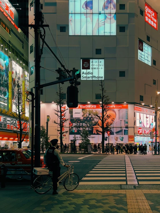 a person is walking across an intersection at night