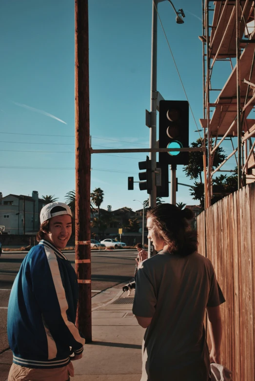 two young people at an intersection by a stop light