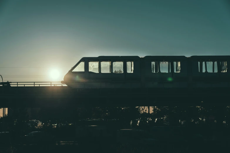 a train on tracks with the sun in the distance