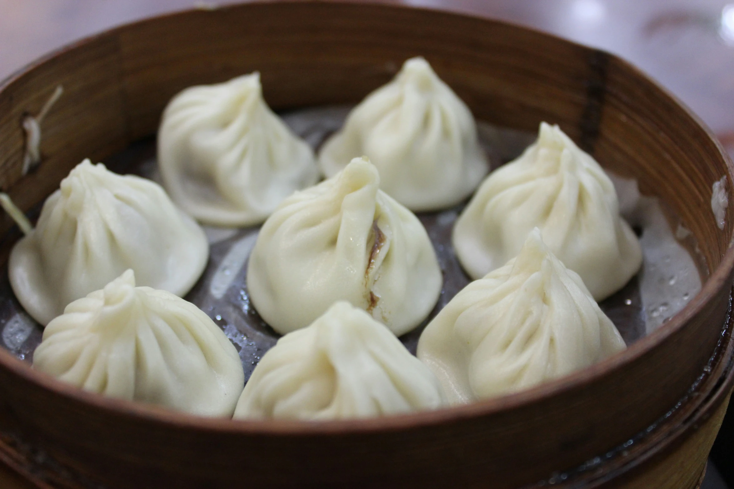 a wooden bowl filled with dumplings in ice water