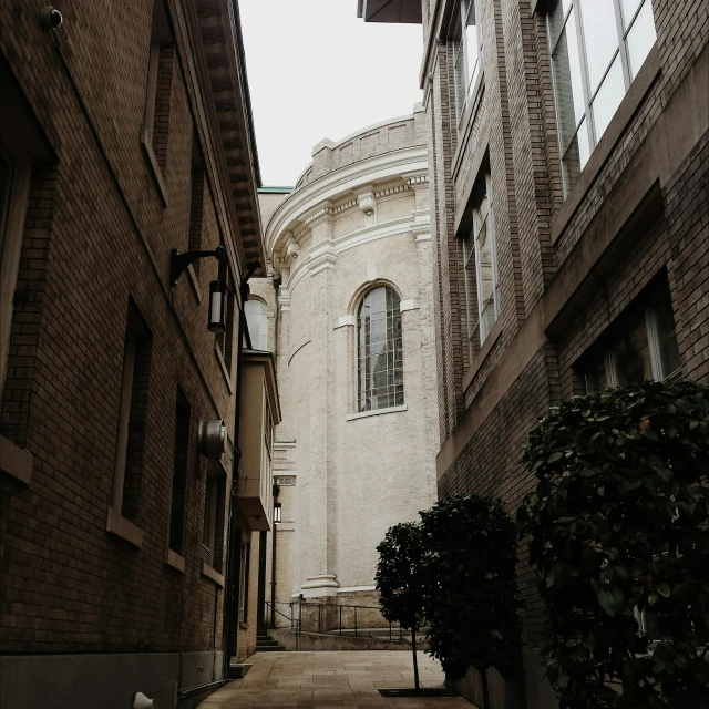 a narrow street between two brick buildings with stairs