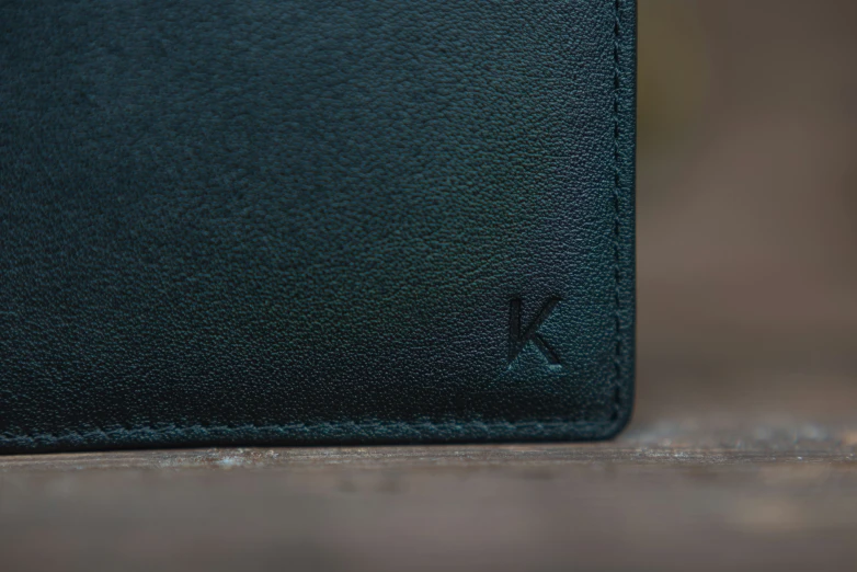 this black leather wallet has a small k on the front