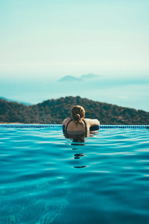 a woman sits on top of a swimming pool