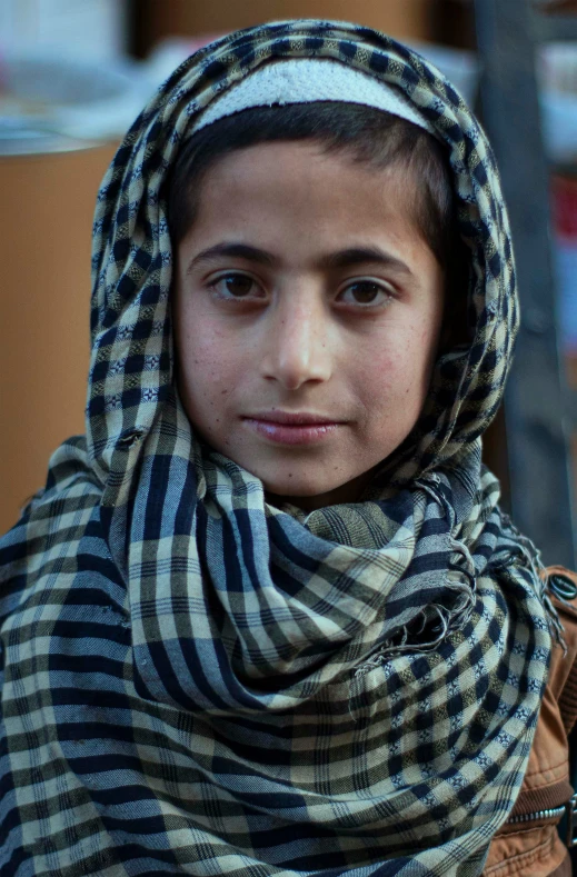 a young man with no head or arm standing wearing a plaid shawl