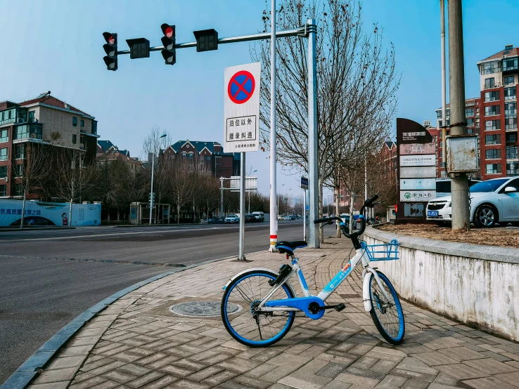 a bicycle  to a sidewalk in front of traffic light