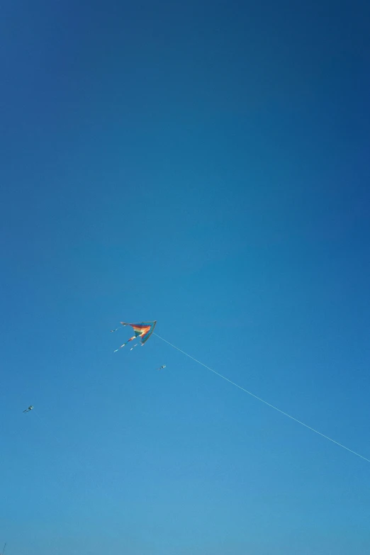 a person is flying a kite in the blue sky