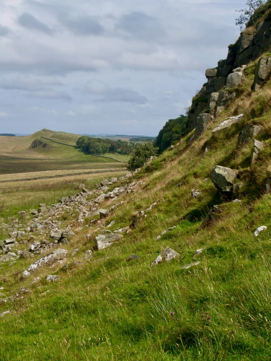 a rocky slope near a green grassy field