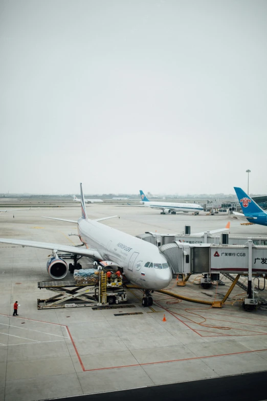 some commercial airplanes parked on the tarmac in an airport