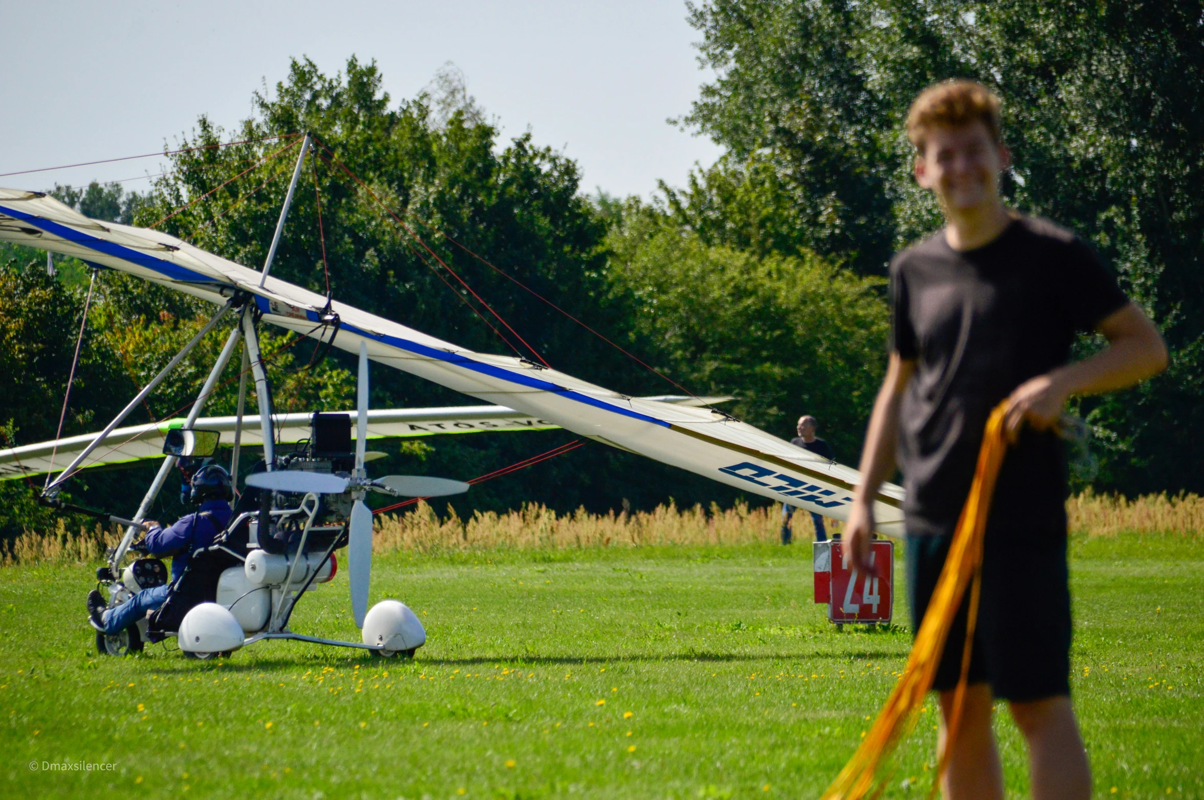 man with frisbee standing next to airplane on grassy area