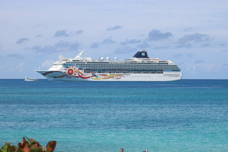 a large ship is seen from the side with ocean and rocks in the background