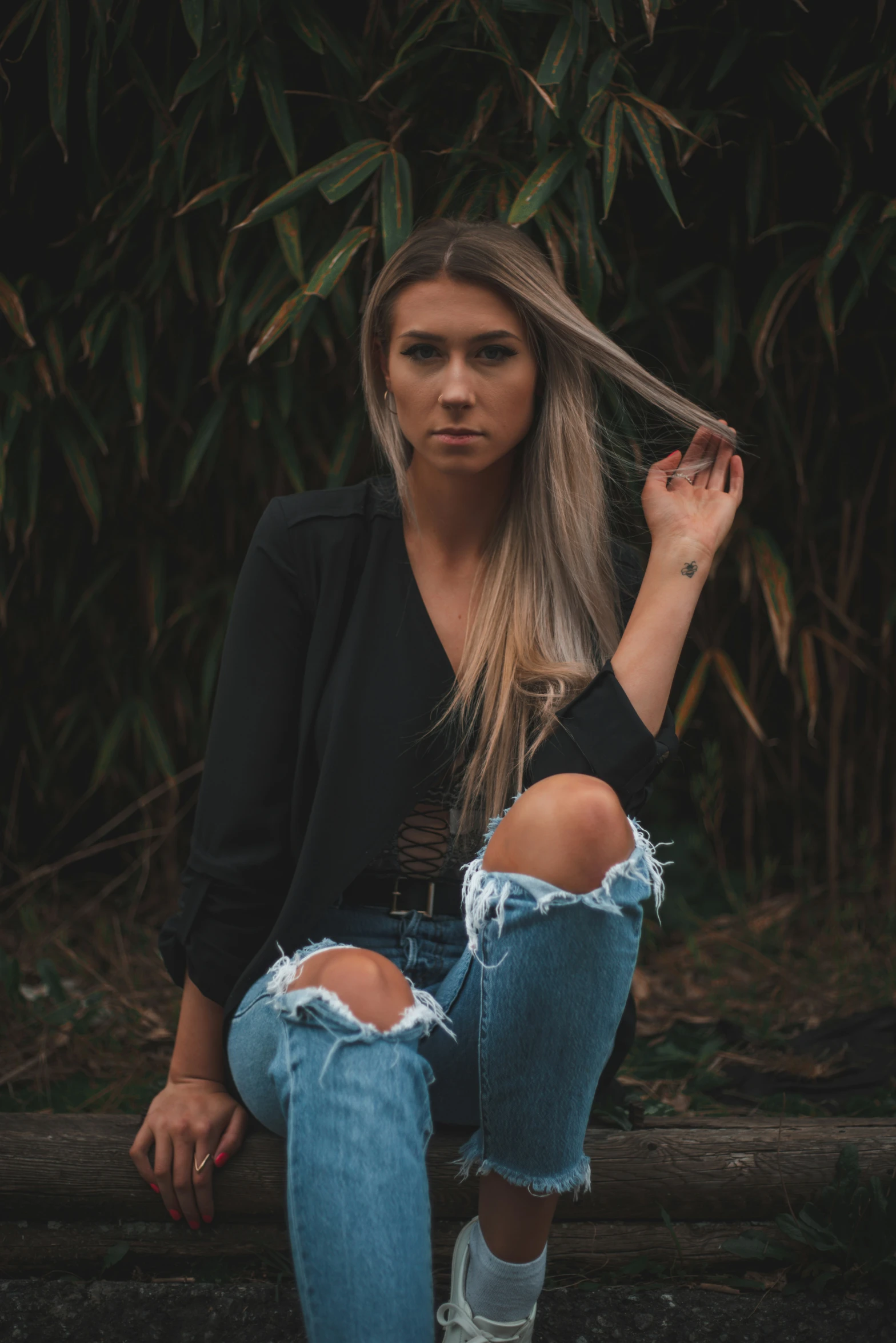 a girl with long hair sitting on a wooden bench