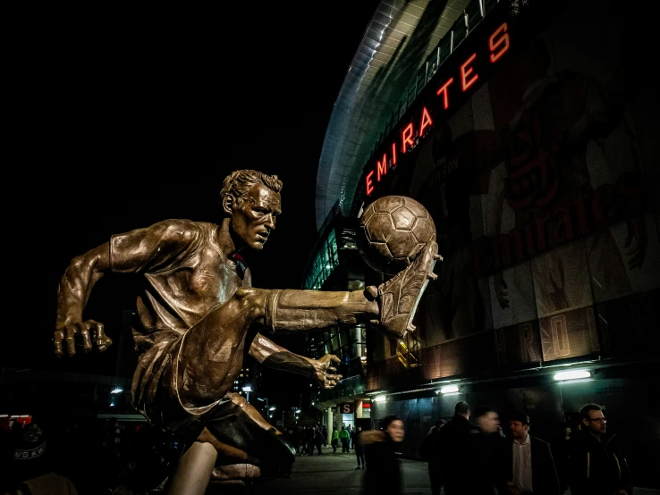 a bronze statue of a young man is in front of the building