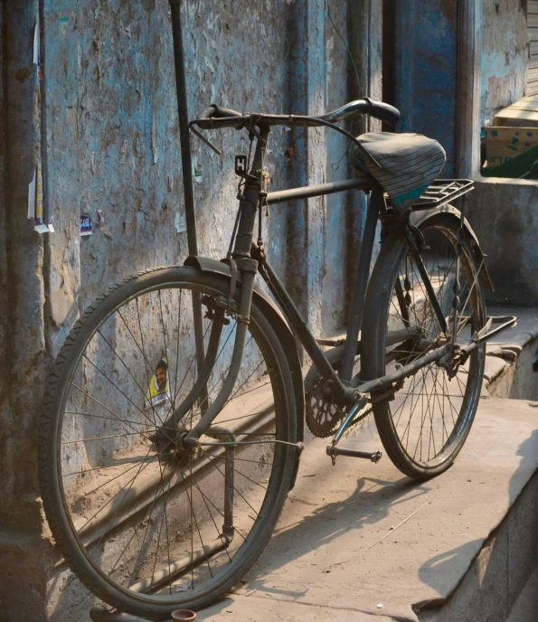 an old bicycle parked next to a run down building