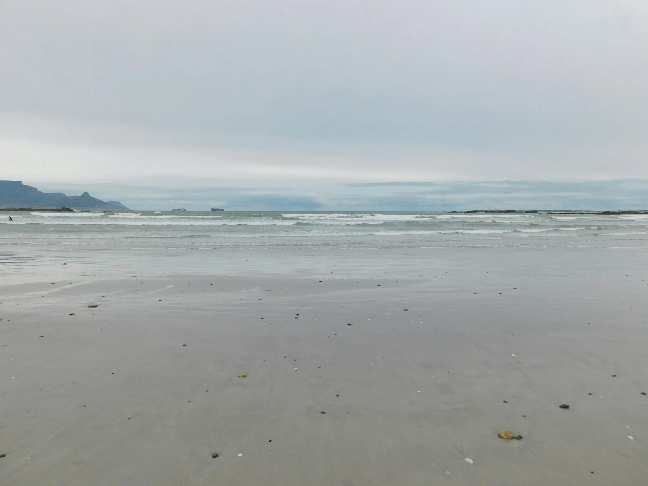 sand that has a wave coming in on the beach