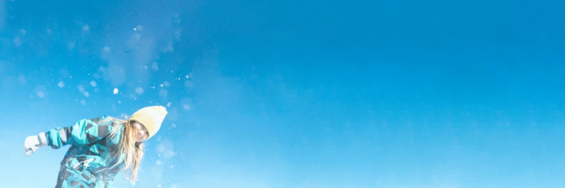 a man in a hat snow boarding down a mountain