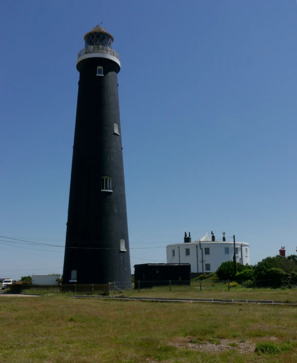 the lighthouse has a black tower with white windows