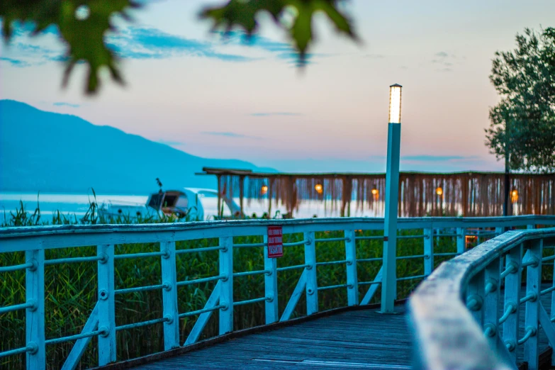 a boardwalk near water and an old pier at twilight