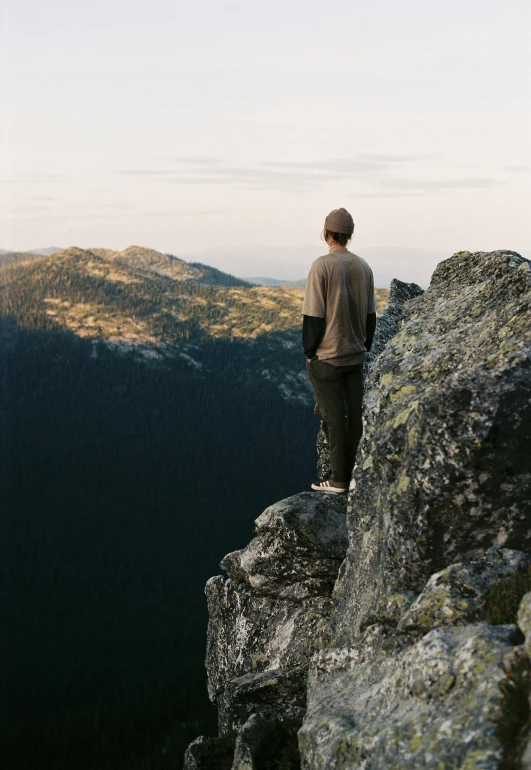 a man standing on top of a large rock