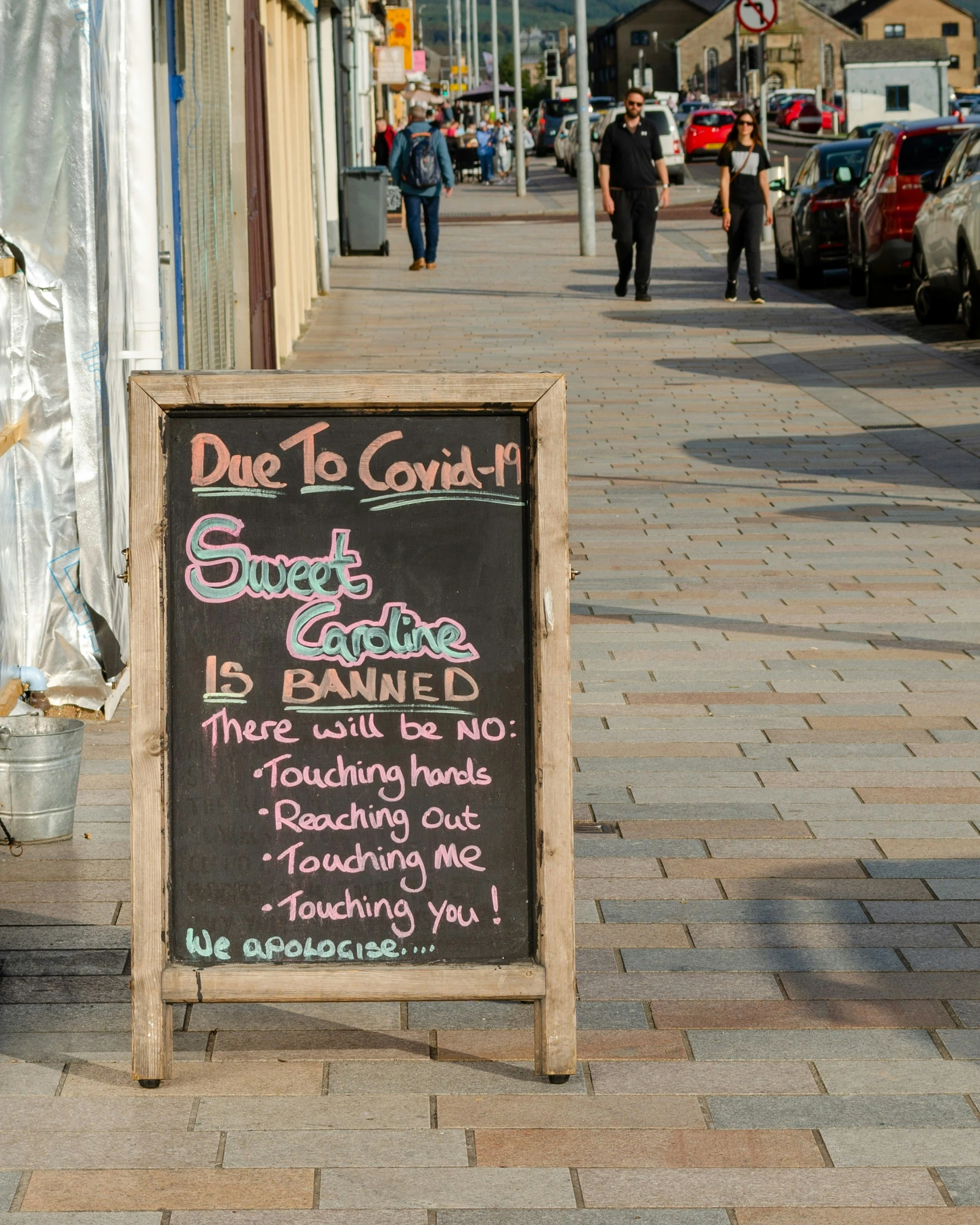 a sign sits on the sidewalk in front of a store